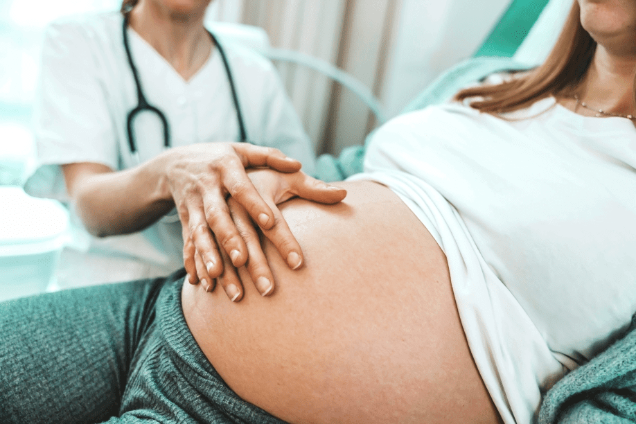 Doctor examining a pregnant woman's belly.