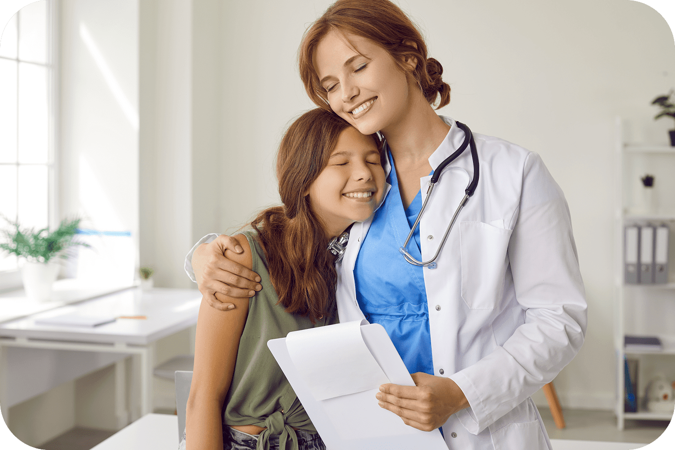 Pediatrician embracing smiling young patient