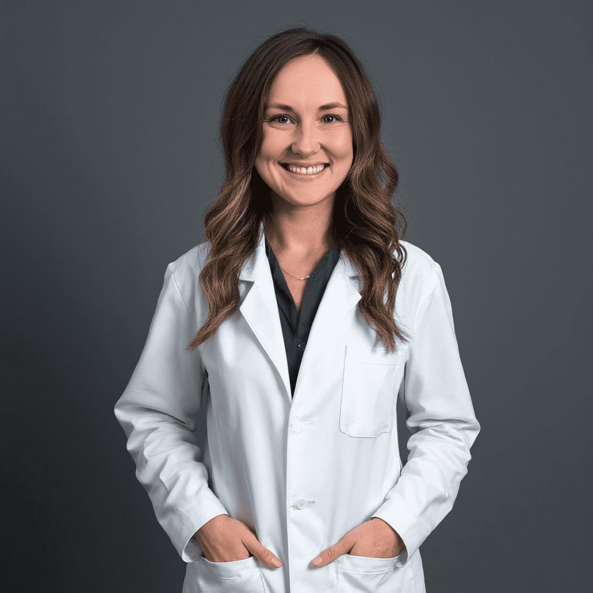 Smiling woman in a white lab coat.