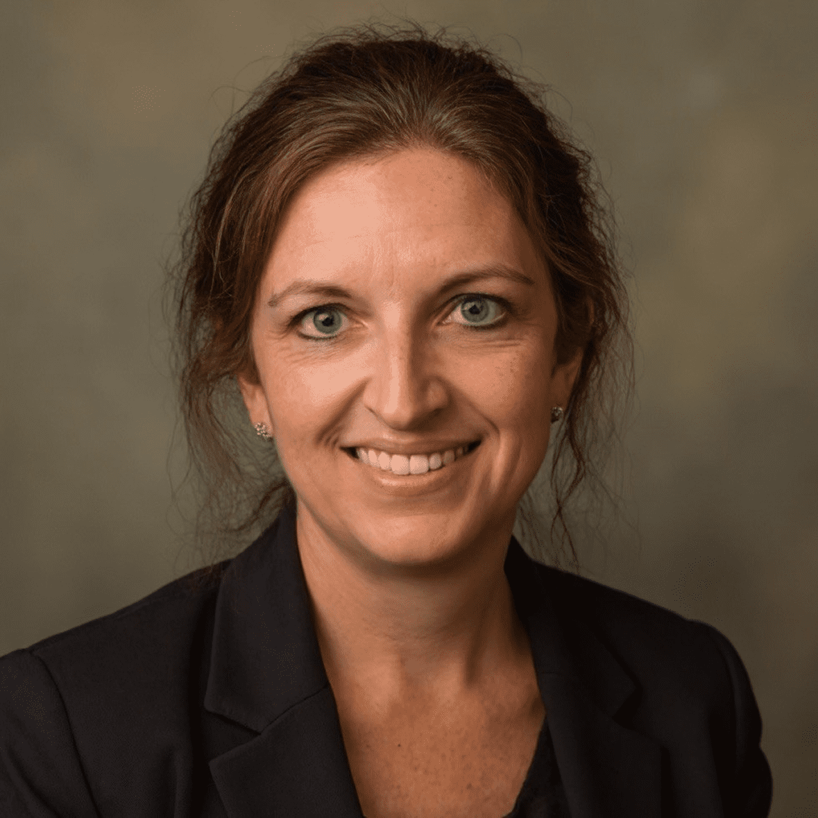 Portrait of a smiling woman in a blazer.