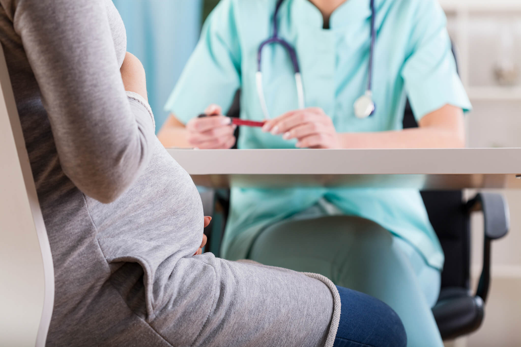 Pregnant woman consulting with a doctor.